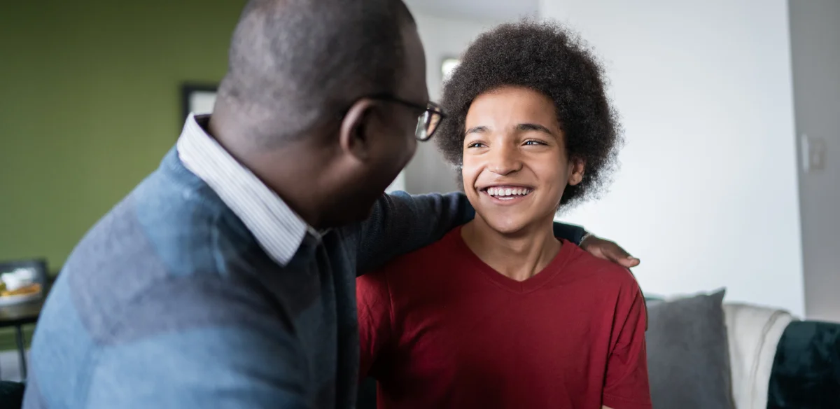father and son looking each other smiling