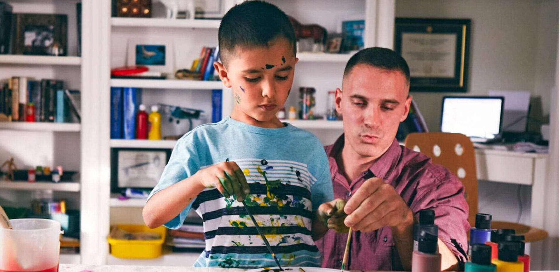 Student painting with his father