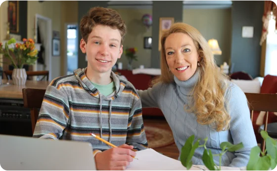 Mother and son taking notes together at home